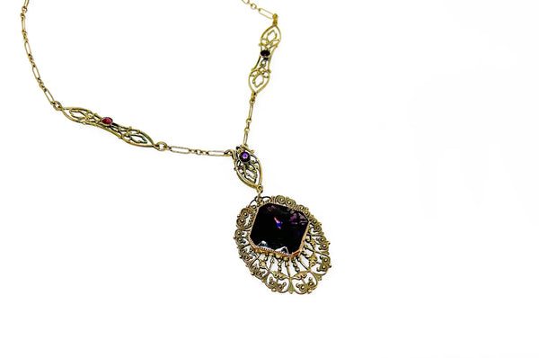 Enhance your jewelry collection with this one-of-a-kind standout piece. Adorned with intricate filigree and glistening purple stones, this necklace exudes elegance and charm. The centerpiece, a stunning diamond-shaped violet stone set in an ornate oval frame, adds a touch of luxury to any outfit