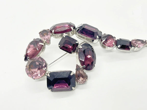 Get ready for all eyes to be on you with this Vintage 4" Purple Question Mark Brooch. From the 1930s, it features varying shades of purple, lavender, and amethyst. This brooch is a true statement piece. The silver tone metal sets off the unique shapes, each prong set for added dimension.