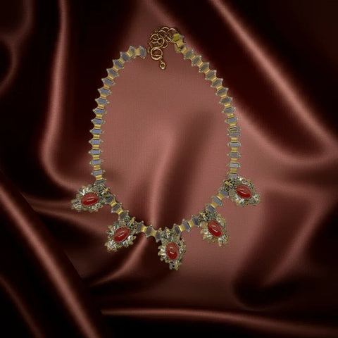Be captivated by this magnificent Victorian Revival Necklace adorned with stunning carnelian colored stones! Five drops with jagged prong settings showcase 14.5mm by 11mm oval stones, giving off an elegant and slightly Gothic vintage vibe.