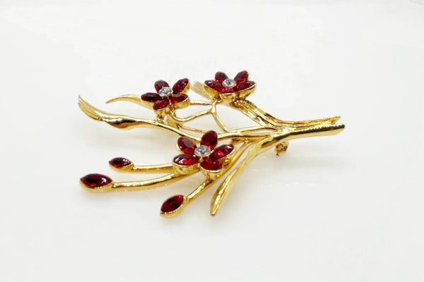 This vintage floral pin will add glamour- three blooms are exquisitely crafted of deep red marquise stones, complemented by a glistening clear rhinestone in the center. This gorgeous piece is in excellent condition and measures 3.25" tall.