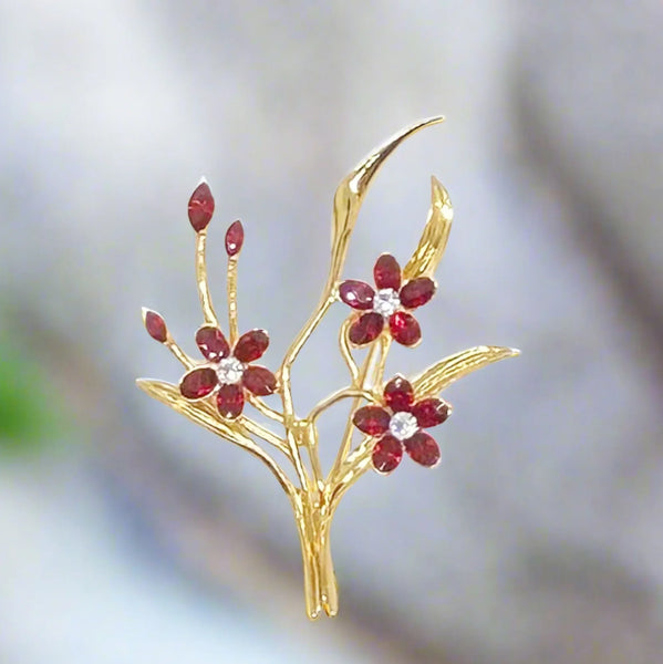 This vintage floral pin will add glamour- three blooms are exquisitely crafted of deep red marquise stones, complemented by a glistening clear rhinestone in the center. This gorgeous piece is in excellent condition and measures 3.25" tall.