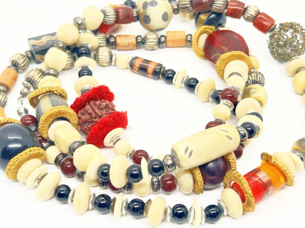 This captivating necklace is a true statement piece, boasting a unique blend of beads in an array of shapes and sizes. The earthy, nature-inspired hues create a stunning visual, with warm tones of red, black, and cream that beautifully coordinate with any fall ensemble. At nearly 60 inches in length, this adaptable infinity necklace is designed without a clasp, providing endless styling possibilities.