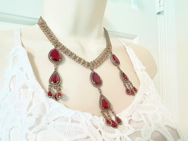 Experience breathtaking beauty with our exclusive Ornate Vintage Drop Necklace. Radiant red teardrop stones set in three long cascading drops, topped with two more tiers of red teardrops, create an eye-catching sparkle that will leave everyone awestruck.
