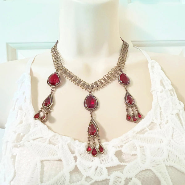 Experience breathtaking beauty with our exclusive Ornate Vintage Drop Necklace. Radiant red teardrop stones set in three long cascading drops, topped with two more tiers of red teardrops, create an eye-catching sparkle that will leave everyone awestruck.