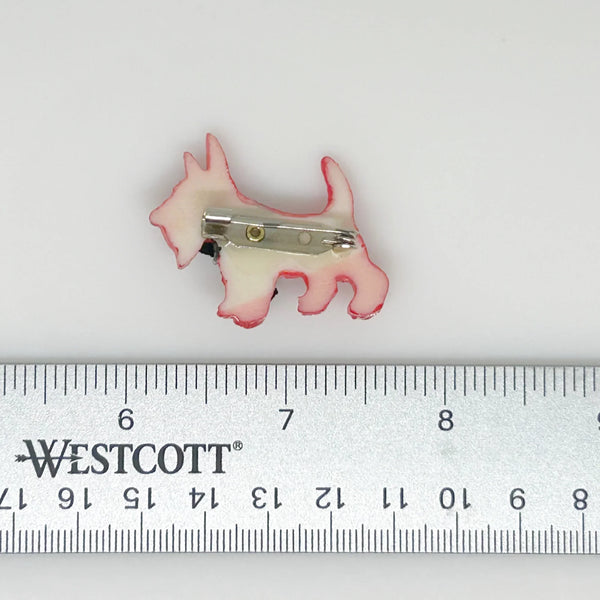 Adopt this captivating and unusual Scottie Dog Brooch, crafted in a bold red hue with a lavish black ribbon bow adorning its neck. Measuring 1.25" in width, it is in impeccable condition. His black collar and nose complete the look. 