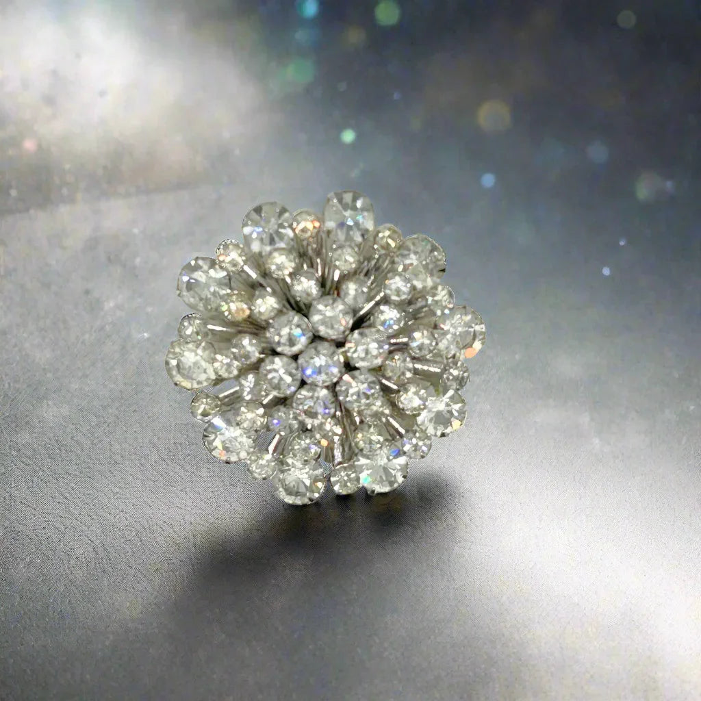 This extraordinary vintage rhinestone brooch features several layers of brilliant, round, sparking stones of varying sizes, measuring 2" across. It The back of the brooch is stunning, showcasing exquisite metalwork and reflecting its excellent condition. Add these details to make the brooch even more enticing