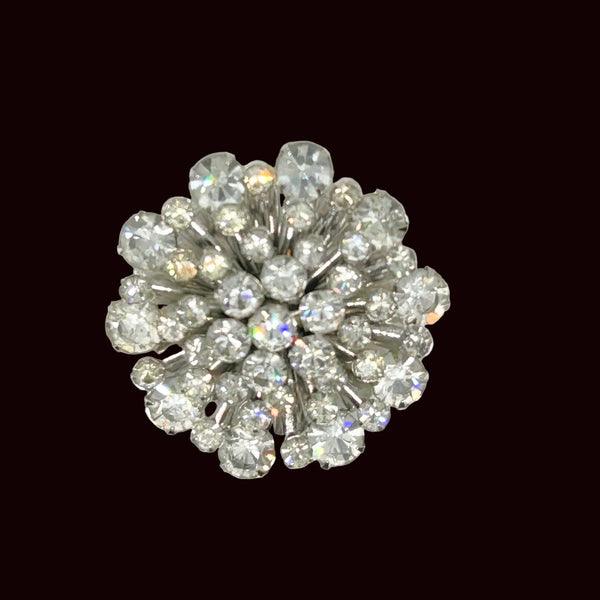 This extraordinary vintage rhinestone brooch features several layers of brilliant, round, sparking stones of varying sizes, measuring 2" across. The back of the brooch is stunning, showcasing exquisite metalwork and reflecting its excellent condition.