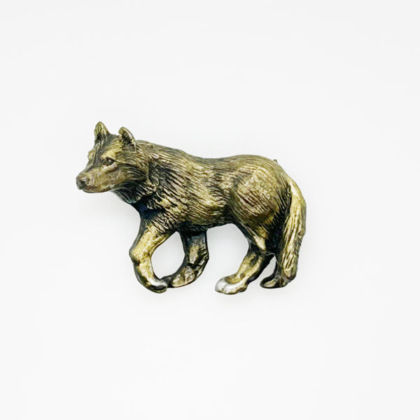 Antiqued bronze wolf brooch pin with highly detailed textured fur on a plain white background