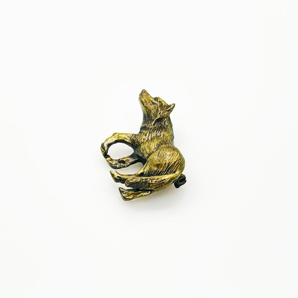 Antiqued bronze wolf brooch pin with highly detailed textured fur on a plain white background