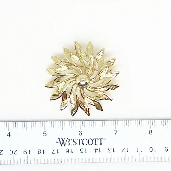 Celebrate timeless elegance with this Sarah Coventry Gold Tone Sunburst Flower Brooch. Featuring a beautifully textured gold-tone design, this vintage piece captures the radiant energy of a blossoming flower or a glowing sunburst.