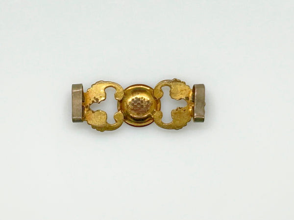 Antique Victorian monogrammed watch slide in gold-tone metal. Features a round hand-engraved monogram center and highly detailed repoussé scrollwork side accents, perfect as a jewelry making component