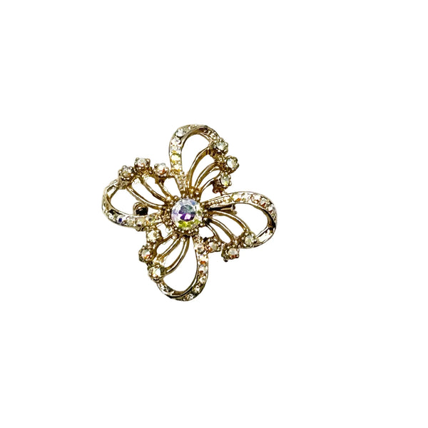 This is a three dimensional vintage ribbon brooch ;featuring clear rhinestones and a central aurora borealis (AB) gemstone, designed in an abstract floral or bow shape. 