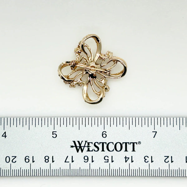 This is a three dimensional vintage ribbon brooch featuring clear rhinestones and a central aurora borealis (AB) gemstone, designed in an abstract floral or bow shape. 