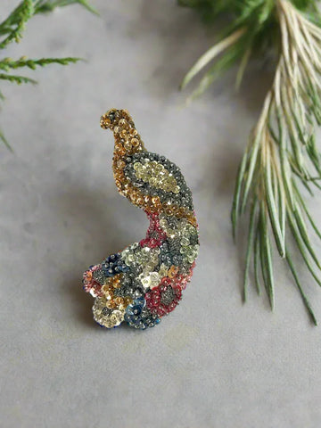 This stunning large peacock brooch showcases an exquisite array of multi-colored sequins in vibrant shades of blue, red, gold, pink, and more, capturing the eye with its lively palette. Meticulously handmade on a sturdy black felt backing, it highlights exceptional craftsmanship and attention to detail.