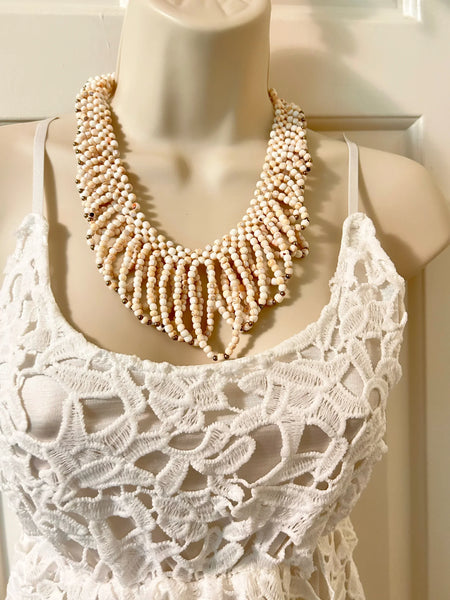 This elaborate vintage necklace showcases delicate loops of the softest light pink beads, beautifully accented with tiny gold beads that add a subtle shimmer. Secured with a classic barrel clasp, it measures 18" in length and gracefully drapes 3" at its longest point, creating a stunning layered effect. Despite its dramatic appearance, 