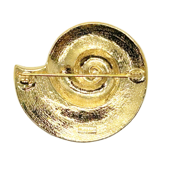 This stunning Trifari brooch captures the elegance of Art Deco design with its spiral seashell silhouette. Crafted in gold-tone metal, it features striking black enamel paired with creamy golden-sand enamel in a sophisticated moire finish.