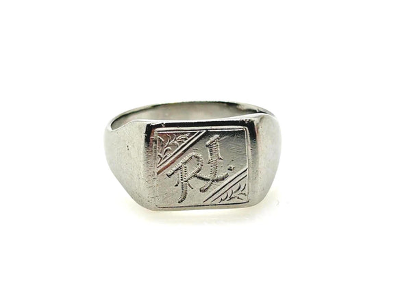 A silver signet ring with engraved decorative details and the letters 'RJ' on a plain white background.