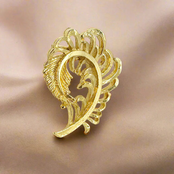Add some vintage charm to your style with Gerry's Vintage Amusing Gold Feather Plume Brooch. The intricate openwork loops and detailed plume end make it a unique and eye-catching piece. Measuring 2" tall and 1.5" wide, it is the perfect size for any outfit.