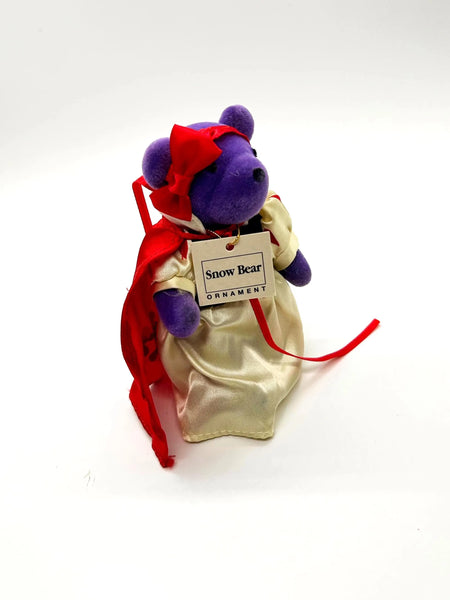 A small, purple plush bear ornament dressed as Snow White. 