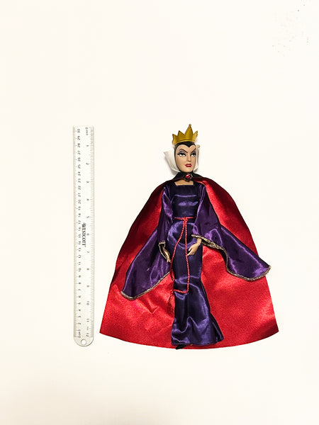 A vintage-style Evil Queen doll with a gold crown, purple gown, and red cape, photographed against a plain white background.