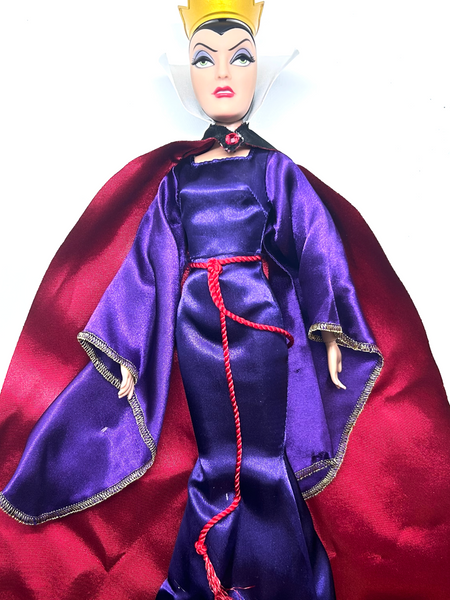 A vintage Disney-style doll dressed as the Evil Queen, featuring a purple satin gown with a red rope belt, a deep red cape with gold trim, a white collar, and a gold crown, set against a plain white background.