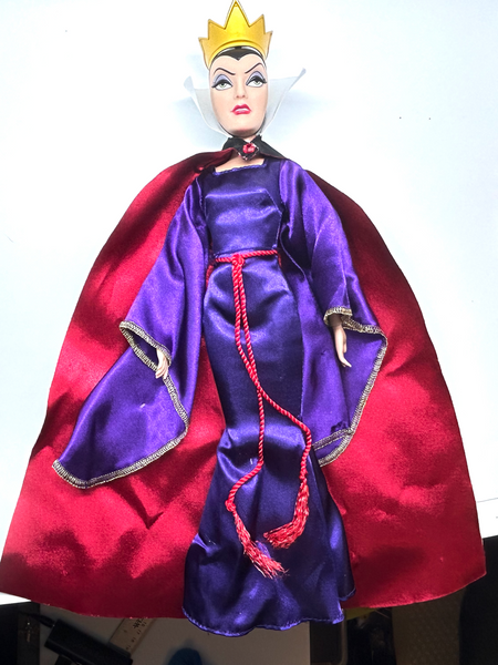 A vintage-style Evil Queen doll with a gold crown, purple gown, and red cape, photographed against a plain white background.