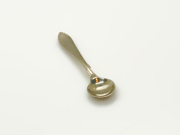A vintage-style silver-toned metal pin with a spoon-shaped head and a long, narrow pin stem, photographed on a plain white background.