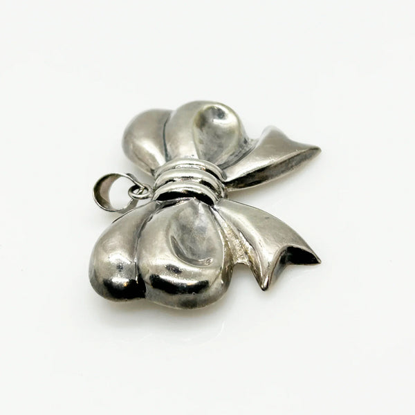Experience the elegance of our Vintage Sterling Silver Bow Pendant/Brooch. Featuring a beautifully puffed, hollow design, this accessory brings refined style to your wardrobe. Measuring a striking 2.5 inches, it is marked with a 925 stamp on the reverse and equipped with a secure pin closure for effortless wear