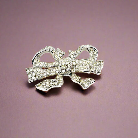 Measuring precisely 1.75 inches, this stunning brooch is meticulously crafted with a rhodium setting and proudly bears the Swarovski signature swan. Every pave-set cryatal stone is present and radiates with captivating brilliance, ensuring this brooch will be a treasured addition to your collection for years to come