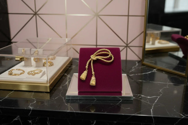 This dramatic Avon gold-tone brooch, a delightful piece from the 1980s, showcases a captivating knotted rope design. The brooch features dangling tassels, adding a touch of vintage charm.