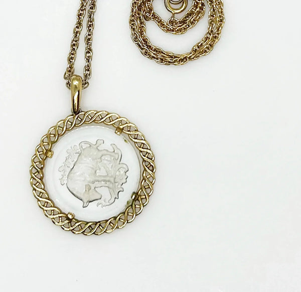 Experience the timeless style and celestial charm of the Trifari zodiac collection with our stunning Taurus pendant. Crafted with intricate details and high-quality materials, this clear glass pendant features a beautifully carved bull design bordered by a lustrous gold tone metal ribbon.