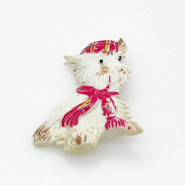 Adorable mid-century white Scottish Terrier brooch sporting a festive red plaid cap and scarf! This charming 1.75" x 1.5" plastic pup features cute brown accents on feet, ears, and face. 