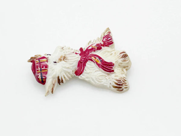 Adorable mid-century white Scottish Terrier brooch sporting a festive red plaid cap and scarf! This charming 1.75" x 1.5" plastic pup features cute brown accents on feet, ears, and face. 