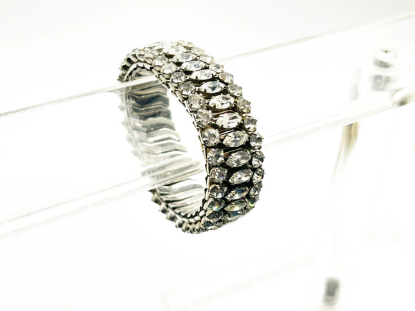 Sparkle up your vintage jewelry collection with this stunning three-row rhinestone bracelet expansion bracelet. Crafted in the classic style beloved from the 1940s through 1960s, this piece showcases brilliant clear glass rhinestones secured in a flexible silver-tone metal band. 
