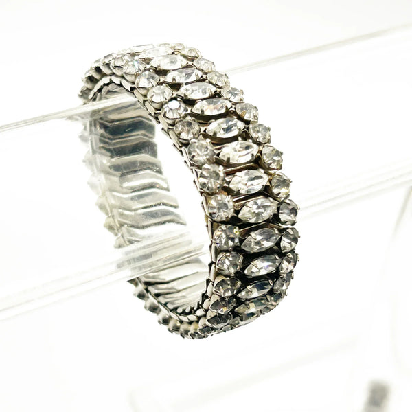 Sparkle up your vintage jewelry collection with this stunning three-row rhinestone bracelet expansion bracelet. Crafted in the classic style beloved from the 1940s through 1960s, this piece showcases brilliant clear glass rhinestones secured in a flexible silver-tone metal band. 