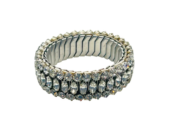 Sparkle up your vintage jewelry collection with this stunning three-row rhinestone bracelet expansion bracelet. Crafted in the classic style beloved from the 1940s through 1960s, this piece showcases brilliant clear glass rhinestones secured in a flexible silver-tone metal band. 