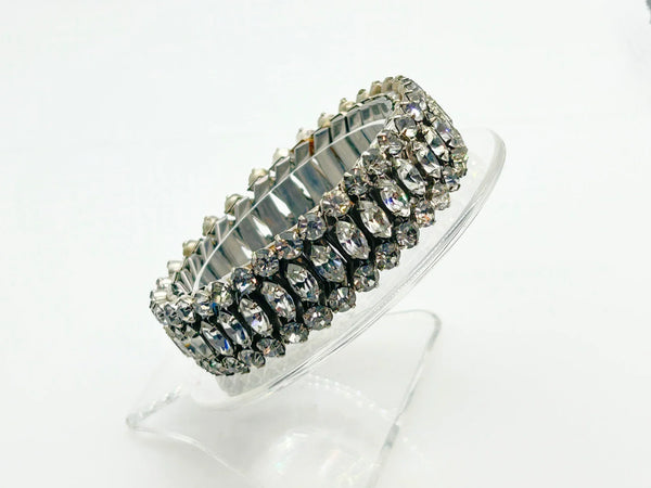 Sparkle up your vintage jewelry collection with this stunning three-row rhinestone bracelet expansion bracelet. Crafted in the classic style beloved from the 1940s through 1960s, this piece showcases brilliant clear glass rhinestones secured in a flexible silver-tone metal band. 