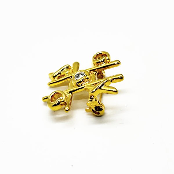 This charming Anne Klein brooch captures the playful spirit of vintage costume jewelry with its clever tic-tac-toe design. Crafted in warm gold tone, the piece features an open-style board complete with X's and O's, crowned by a sparkling clear rhinestone at its center