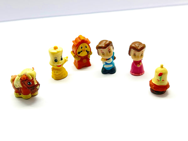 Vintage Disney Squinkies Beauty and the Beast miniature figurines lot of six including Belle, the Prince, Lumiere, Cogsworth, Philippe, and the Enchanted Rose on a white background