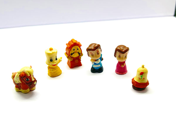 Vintage Disney Squinkies Beauty and the Beast miniature figurines lot of six including Belle, the Prince, Lumiere, Cogsworth, Philippe, and the Enchanted Rose on a white background