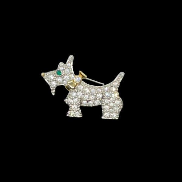This brooch may be small in size, but is big on sparkle. Add a dash of canine charm to your outfit with this adorable vintage terrier brooch! This pint-sized pup brings major bling factor with its dazzling coat of pave set white rhinestones that catch the light with every movement. With its cheerful green eye that seems to wink at admirers, this petite (1.5" across) pin brings personality to any ensemble.