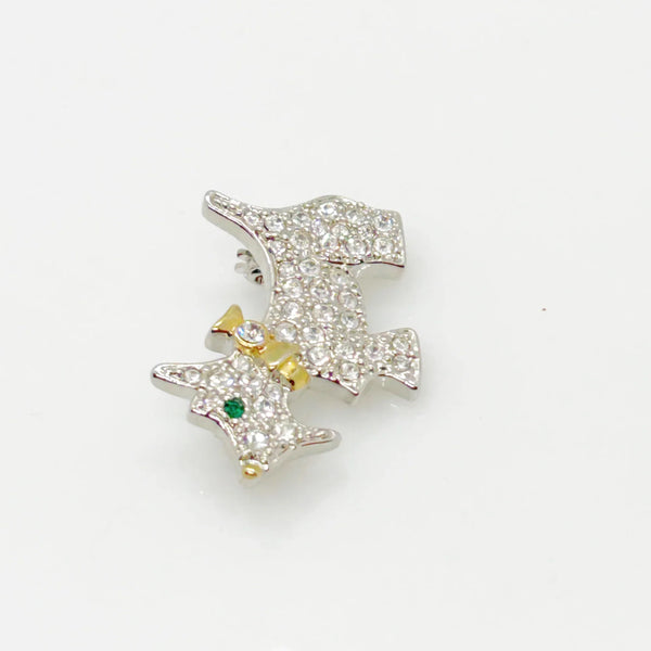 This brooch may be small in size, but is big on sparkle. Add a dash of canine charm to your outfit with this adorable vintage terrier brooch! This pint-sized pup brings major bling factor with its dazzling coat of pave set white rhinestones that catch the light with every movement. With its cheerful green eye that seems to wink at admirers, this petite (1.5" across) pin brings personality to any ensemble.