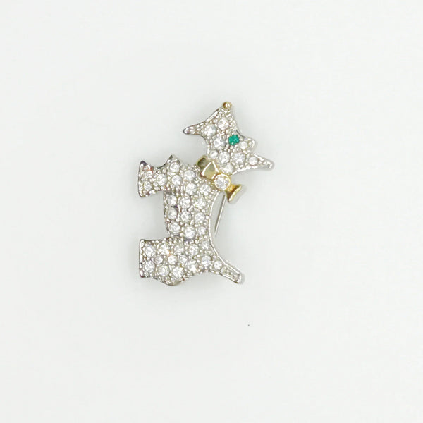 This brooch may be small in size, but is big on sparkle. Add a dash of canine charm to your outfit with this adorable vintage terrier brooch! This pint-sized pup brings major bling factor with its dazzling coat of pave set white rhinestones that catch the light with every movement. With its cheerful green eye that seems to wink at admirers, this petite (1.5" across) pin brings personality to any ensemble.
