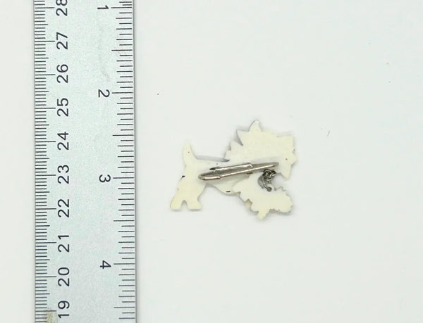 This is such an adorable pin. It is made of two black and white terrier dogs, one larger and the other smaller, puppy. The larger dog measure 1.25” across and wears a red, orange and white checked collar; the puppy wears a solid red collar and measures 1/2” across. 