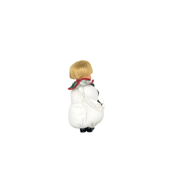 Back view of a vintage 2001 Mattel Barbie Kelly Club Snowman Tommy holiday ornament doll, showing his blonde bob hair, red and green patterned collar, white plush snowman body suit, and black shoes against a clean white background
