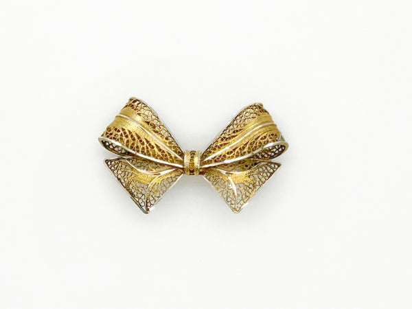 Vintage gold filigree bow-shaped brooch with intricate openwork wire detailing, measured at 1.75 inches, displayed on a clean white background.