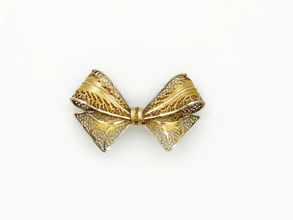 Vintage gold filigree bow-shaped brooch with intricate openwork wire detailing, measured at 1.75 inches, displayed on a clean white background.