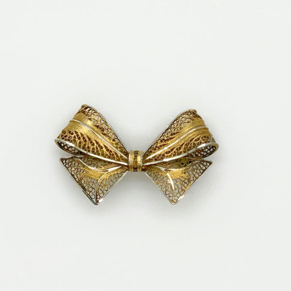 Vintage gold filigree bow-shaped brooch with intricate openwork wire detailing, measured at 1.75 inches, displayed on a clean white background.