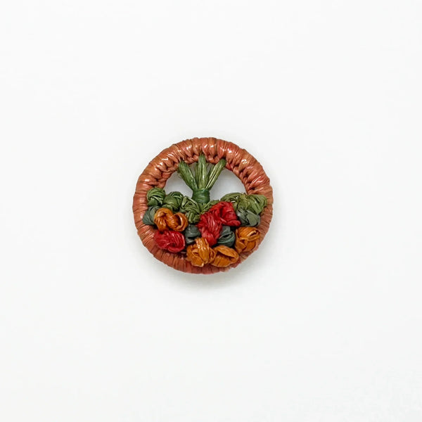 This beautiful antique brooch, likely dating back to the early 1900s, is quite rare. It showcases a charming design with colored straw wrapped around a circular frame. Inside, you'll find a delicate, hand-crafted tree or bouquet made from fine threads.