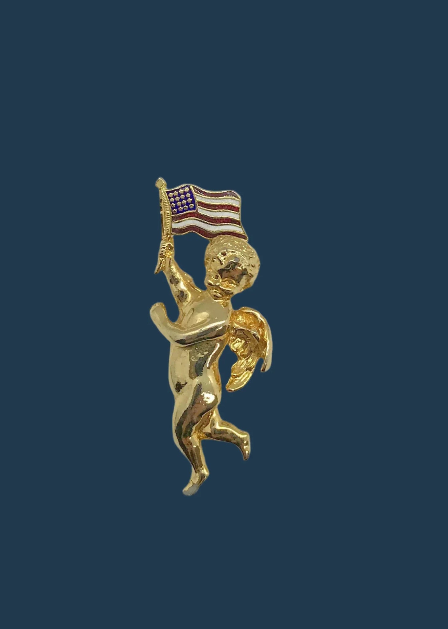 Experience a piece of vintage Americana with this charming cherub brooch. Its proud display of the American flag is sure to make a bold statement wherever you go. Measuring at 2 1/4" in length, this brooch is an excellent addition to any collection.